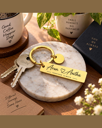 Personalised gold couple keychain engraved with two names, a heart and the tagline Together Always, on a marble coaster with keys